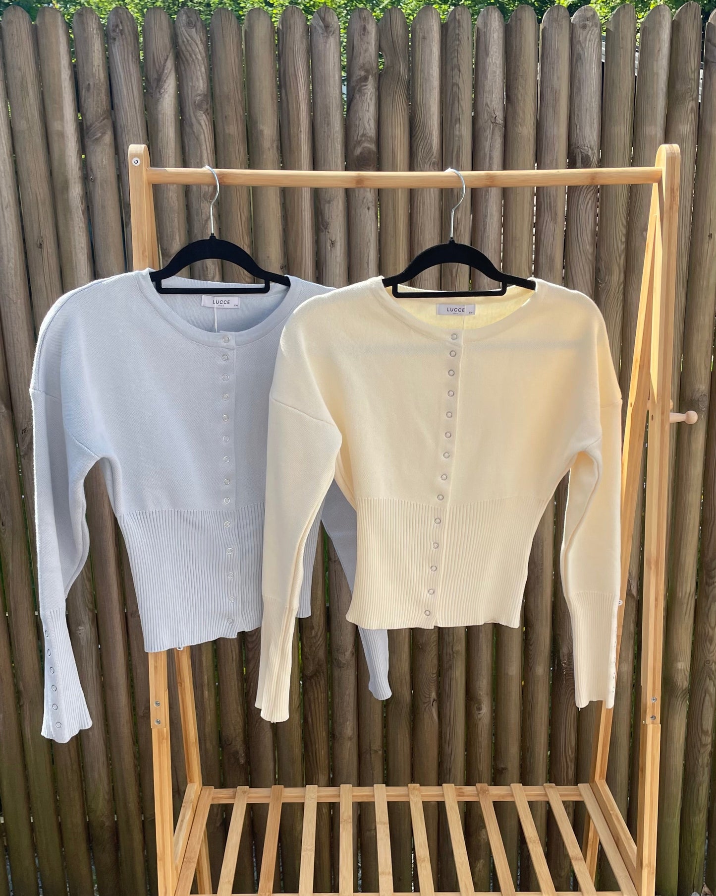 Cardigan bleu pastel en maille texturée avec un côté rond et une fermeture à boutons devant