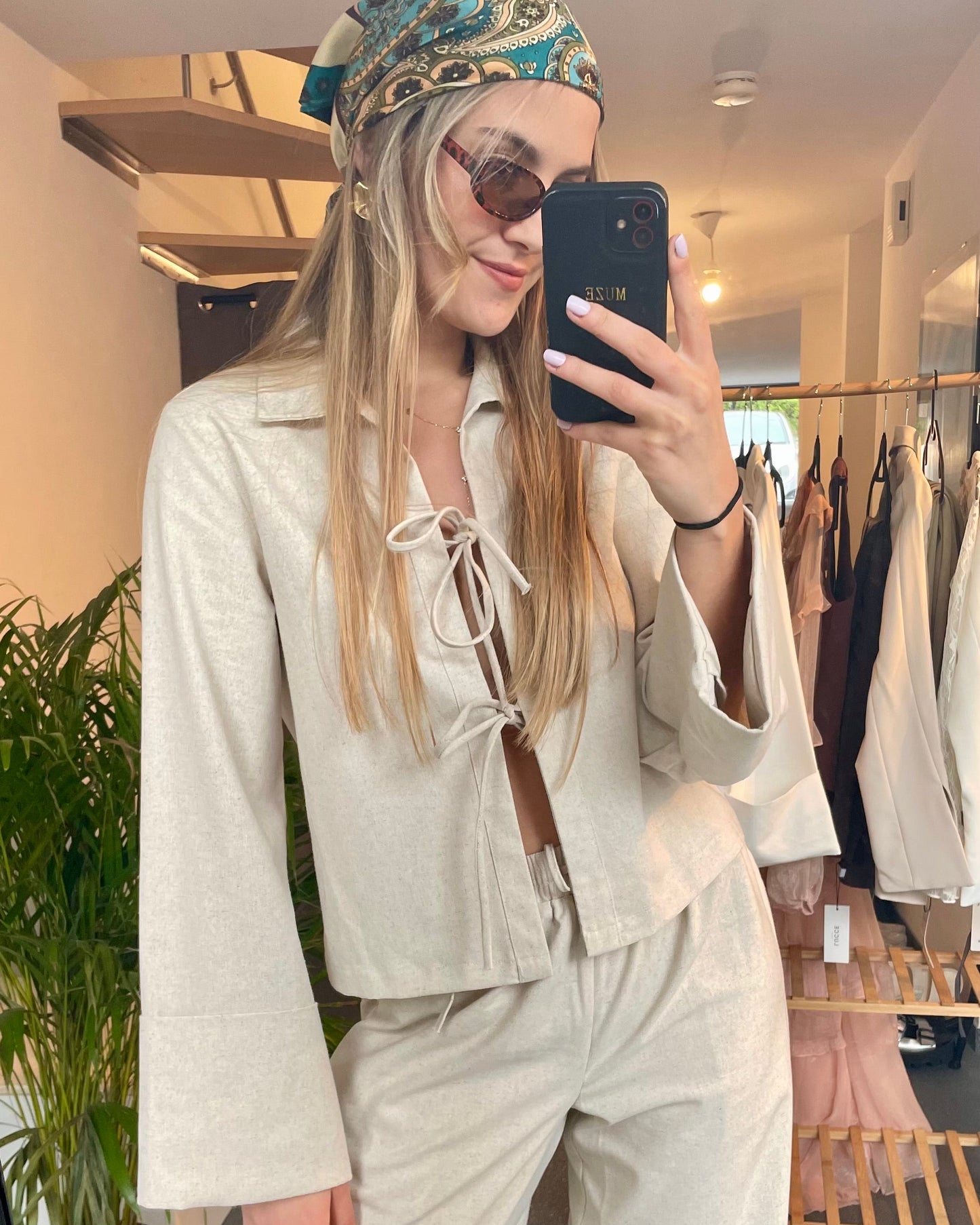 Blouse beige en coton-lin à manches longues avec poignets larges. Coupe droite légèrement courte avec des liens à nouer à l’avant.