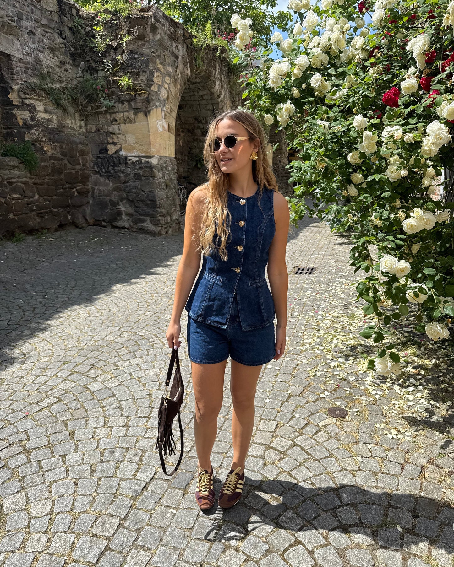 Top sans manche en denim cintré. Avec des boutons dorés et une encolure ronde.
