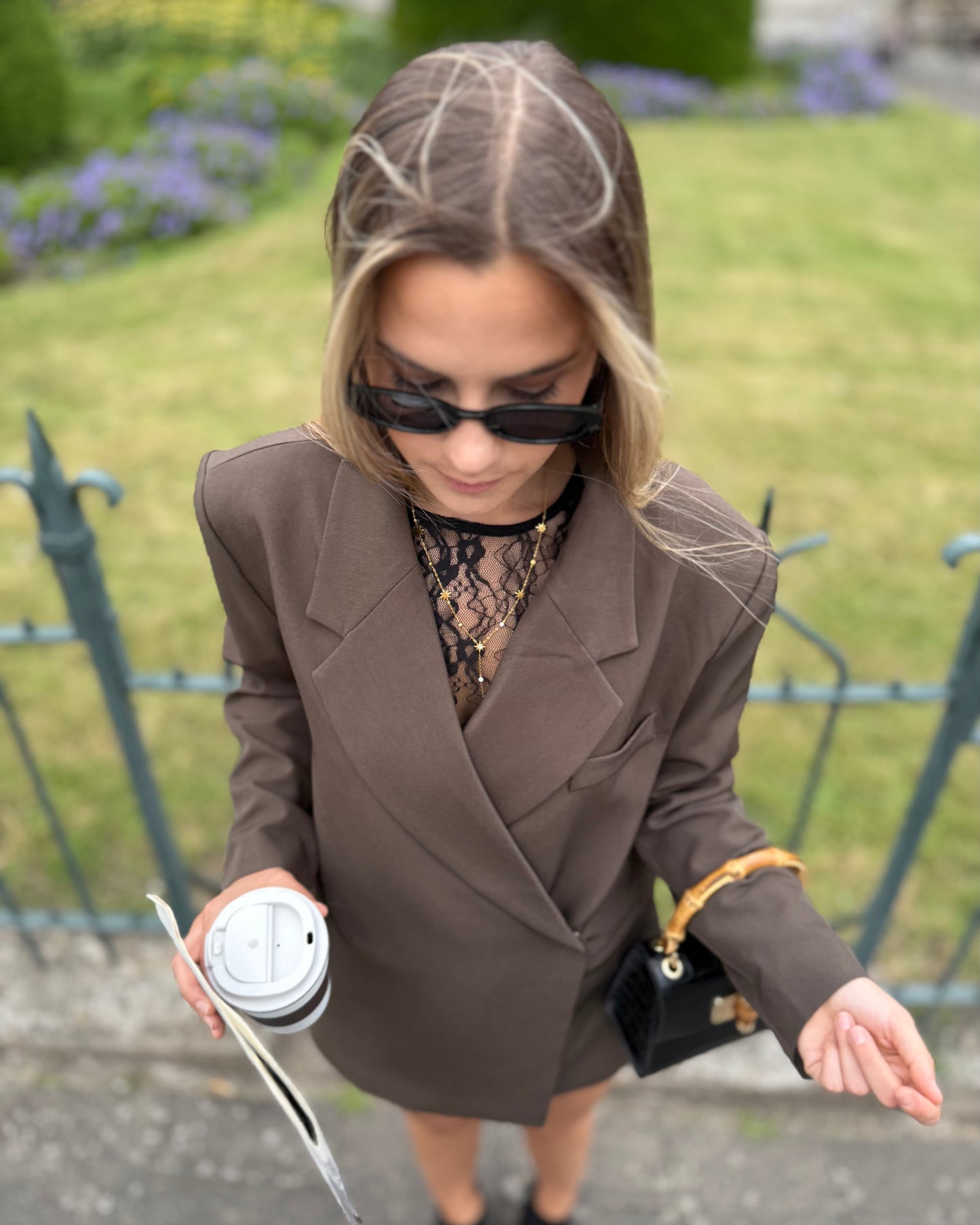 Blouse noire en dentelles légère et transparente. Coupe moulante avec des longues manches évasées et une dentelle florale.