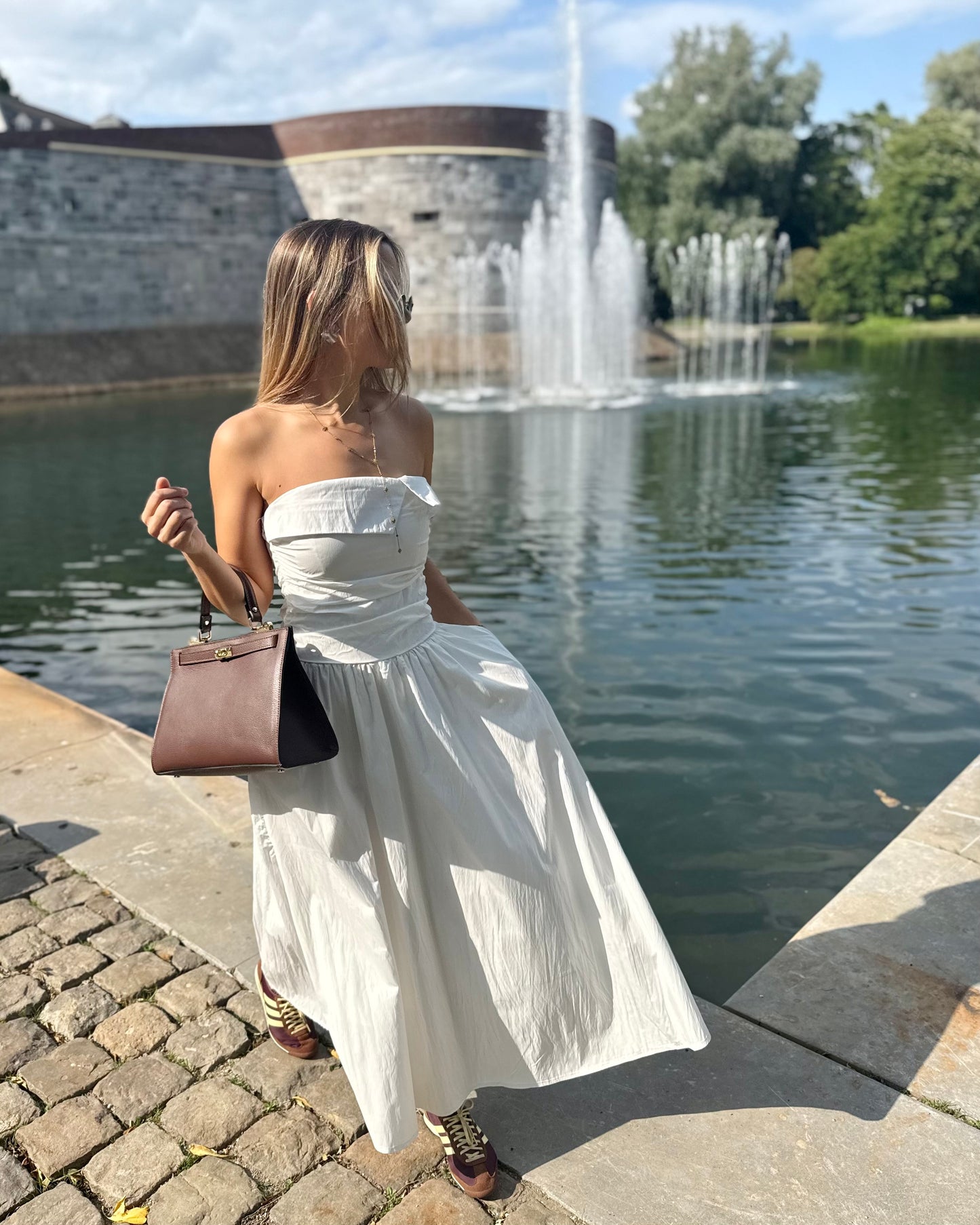 Robe blanche longue bustier. Avec effet drapé et fines bretelles. Deux poches à l’avant.