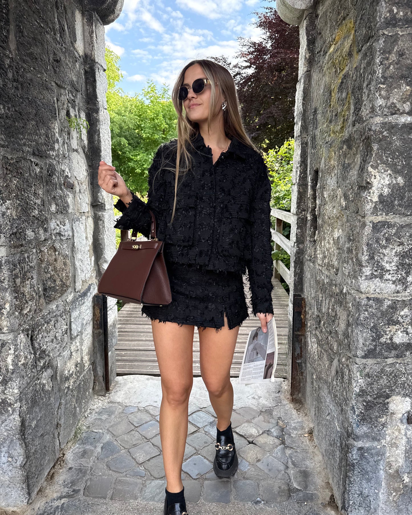 Veste noire en tweed avec deux poches à l’avant. Matière épaisse. Short noir assorti