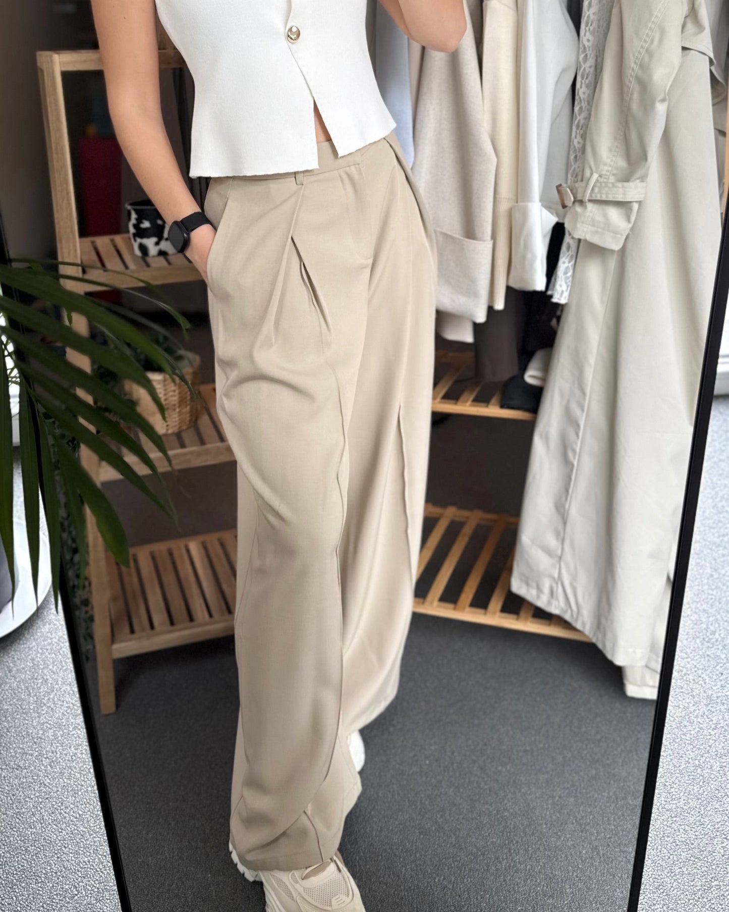 Pantalon tailleur beige taille haute. Coupe longue et fluide avec une fausse poche derrière.