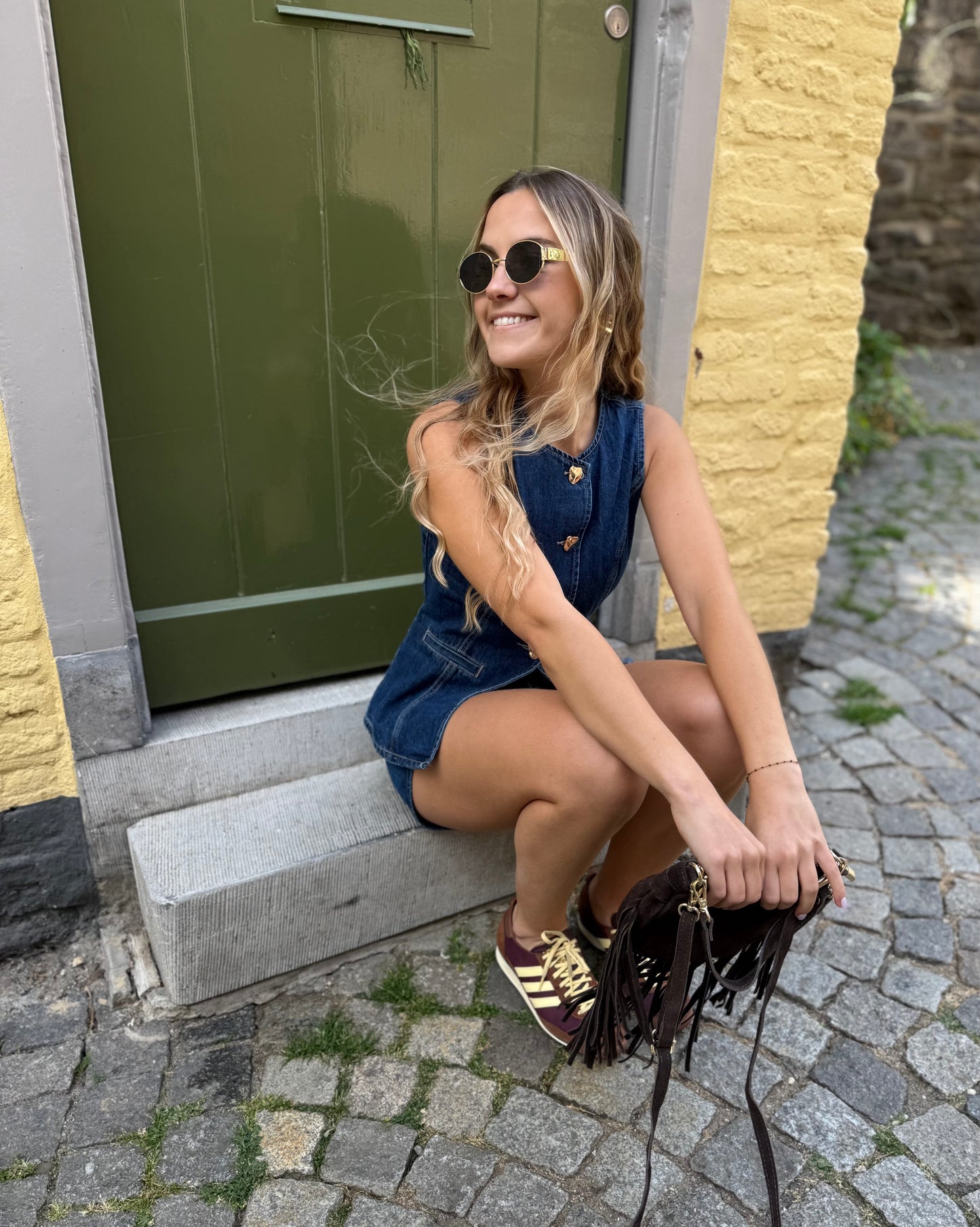 Top sans manche en denim cintré. Avec des boutons dorés et une encolure ronde. 