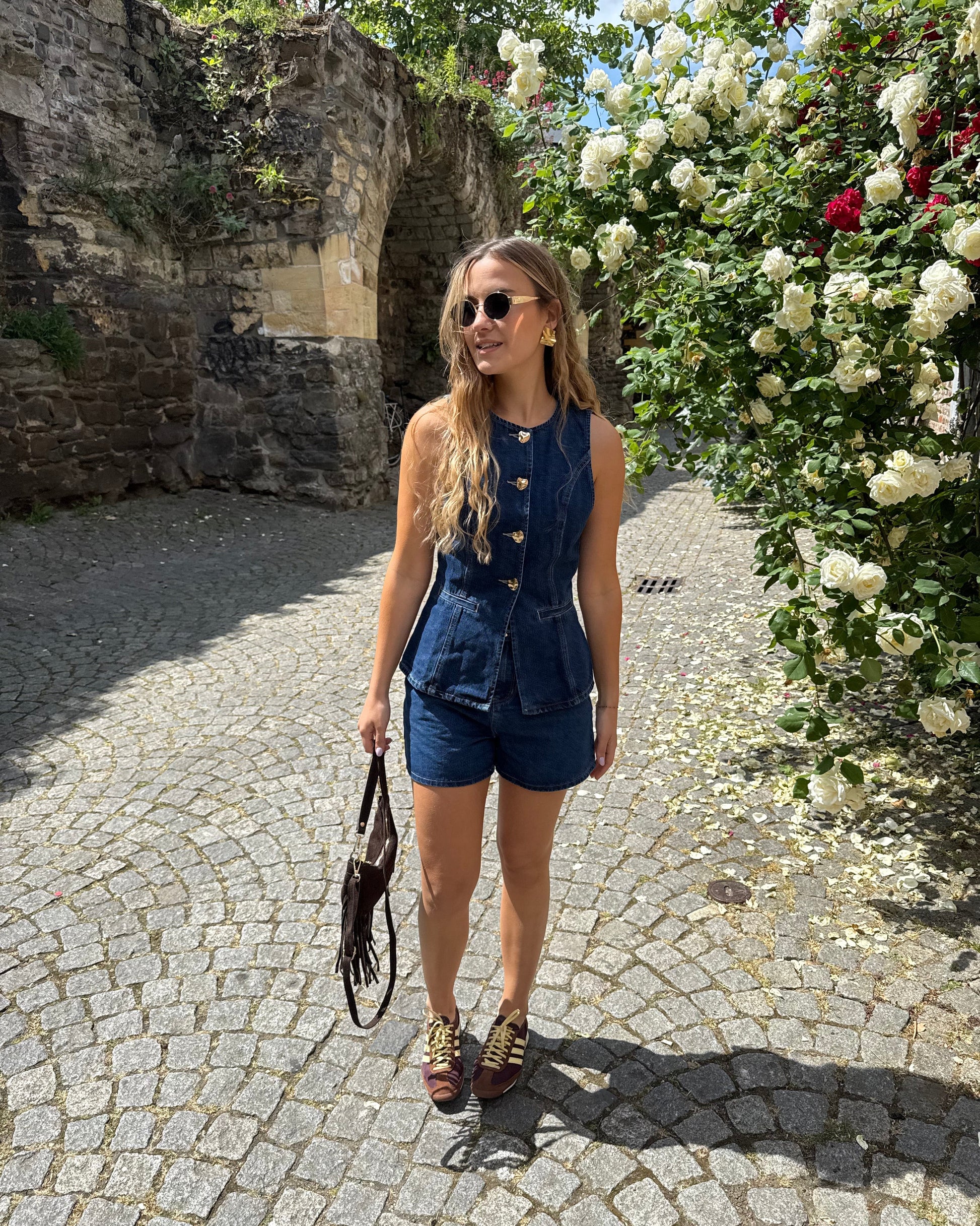 Top sans manche en denim cintré. Avec des boutons dorés et une encolure ronde. 