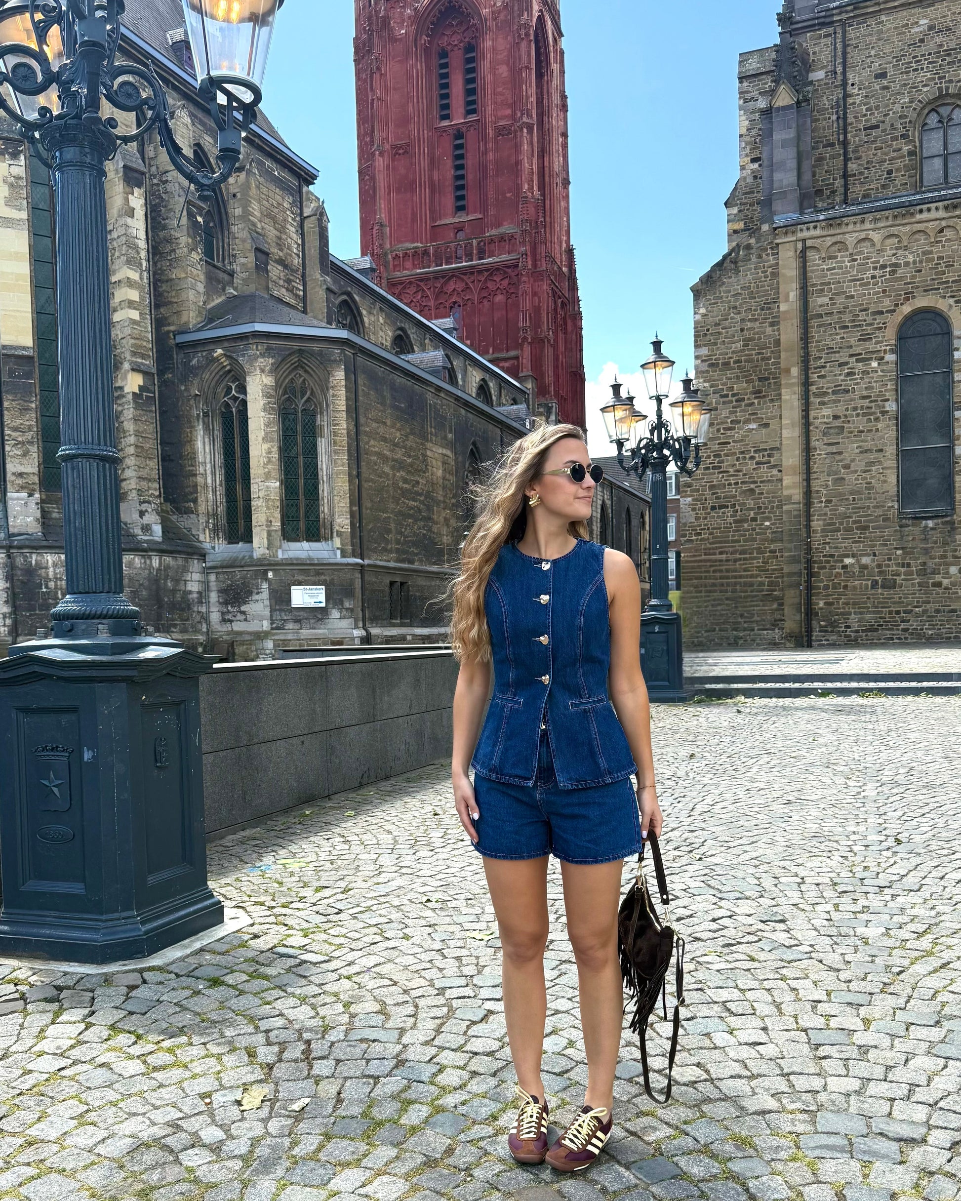 Top sans manche en denim cintré. Avec des boutons dorés et une encolure ronde. 