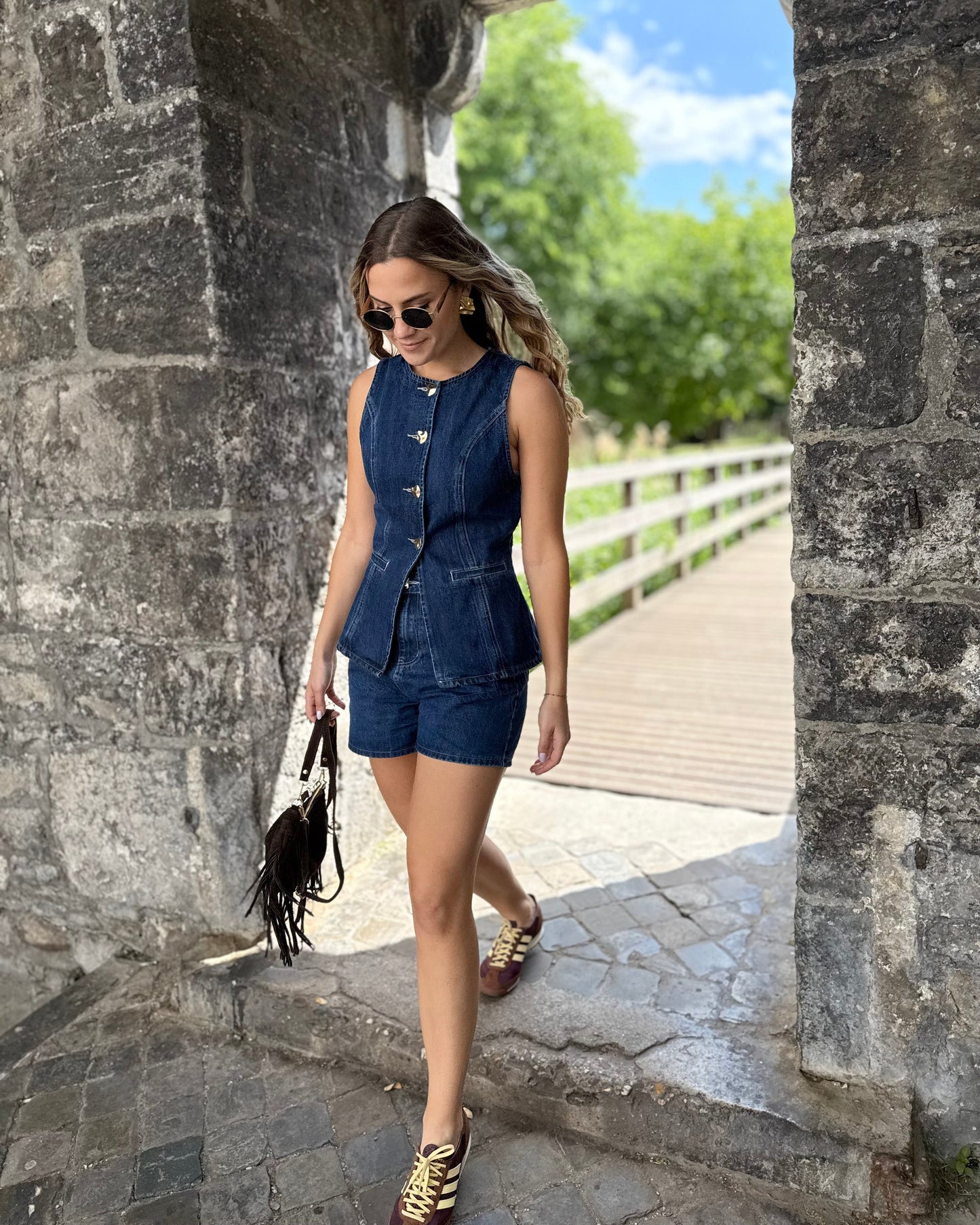 Top sans manche en denim cintré. Avec des boutons dorés et une encolure ronde. 