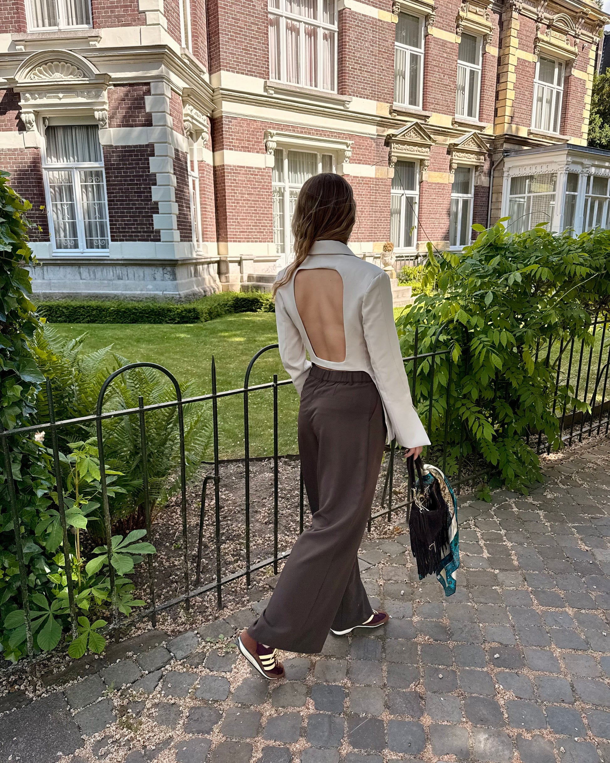 Blazer beige dos un et cintré à la taille. Manches longues et légèrement évasées. 