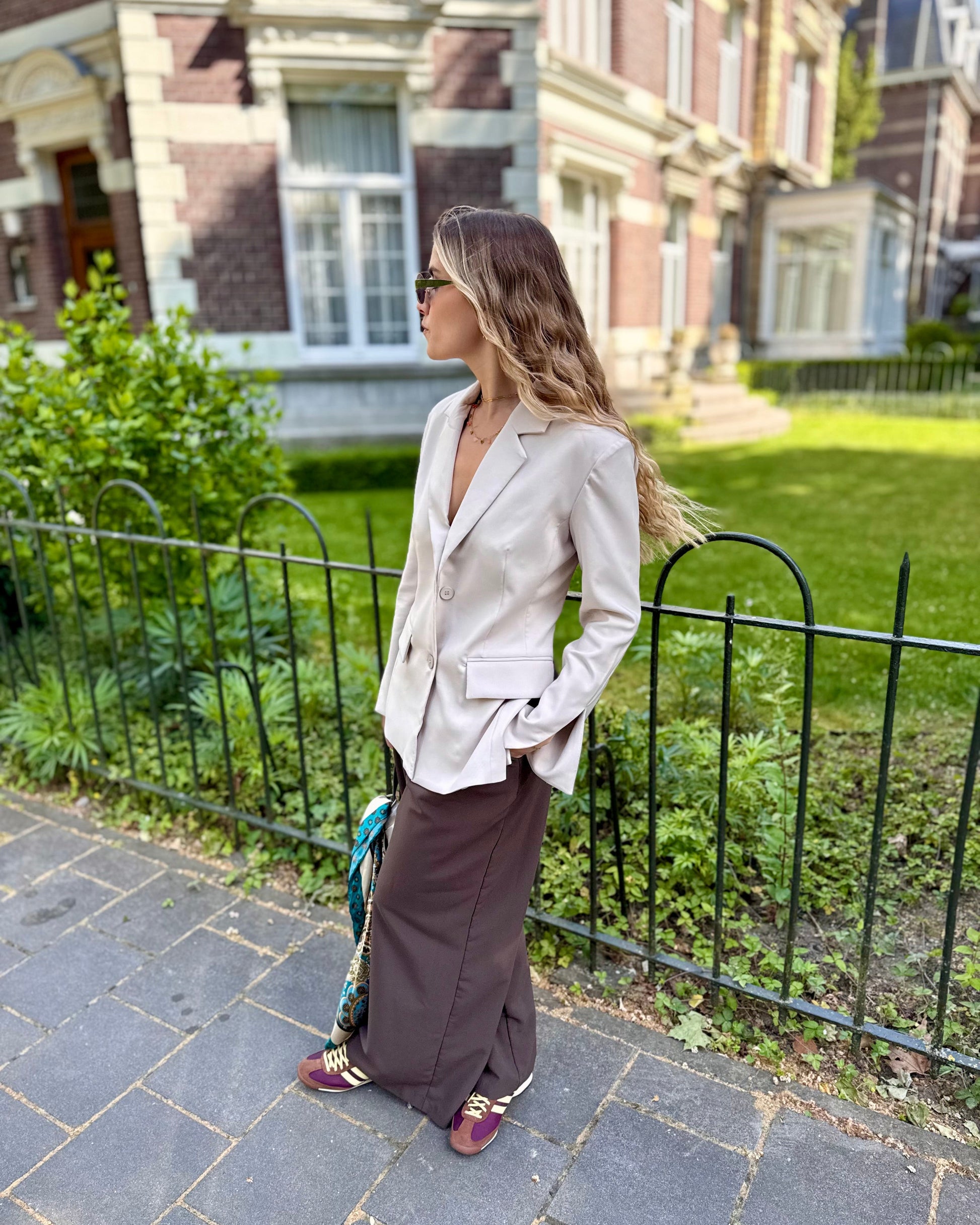 Blazer beige dos un et cintré à la taille. Manches longues et légèrement évasées. 