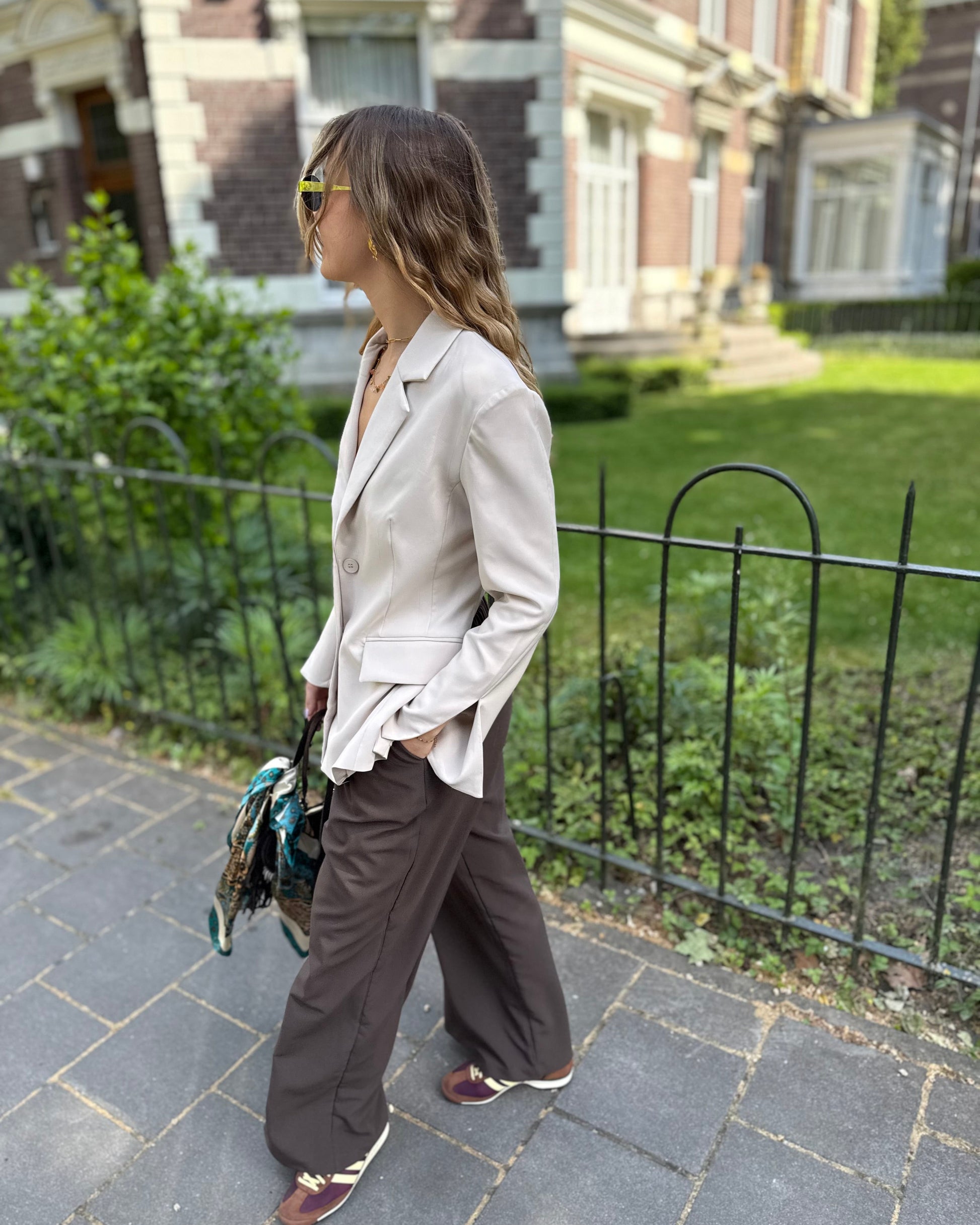 Blazer beige dos un et cintré à la taille. Manches longues et légèrement évasées. 