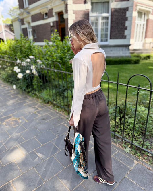 Blazer beige dos un et cintré à la taille. Manches longues et légèrement évasées. 