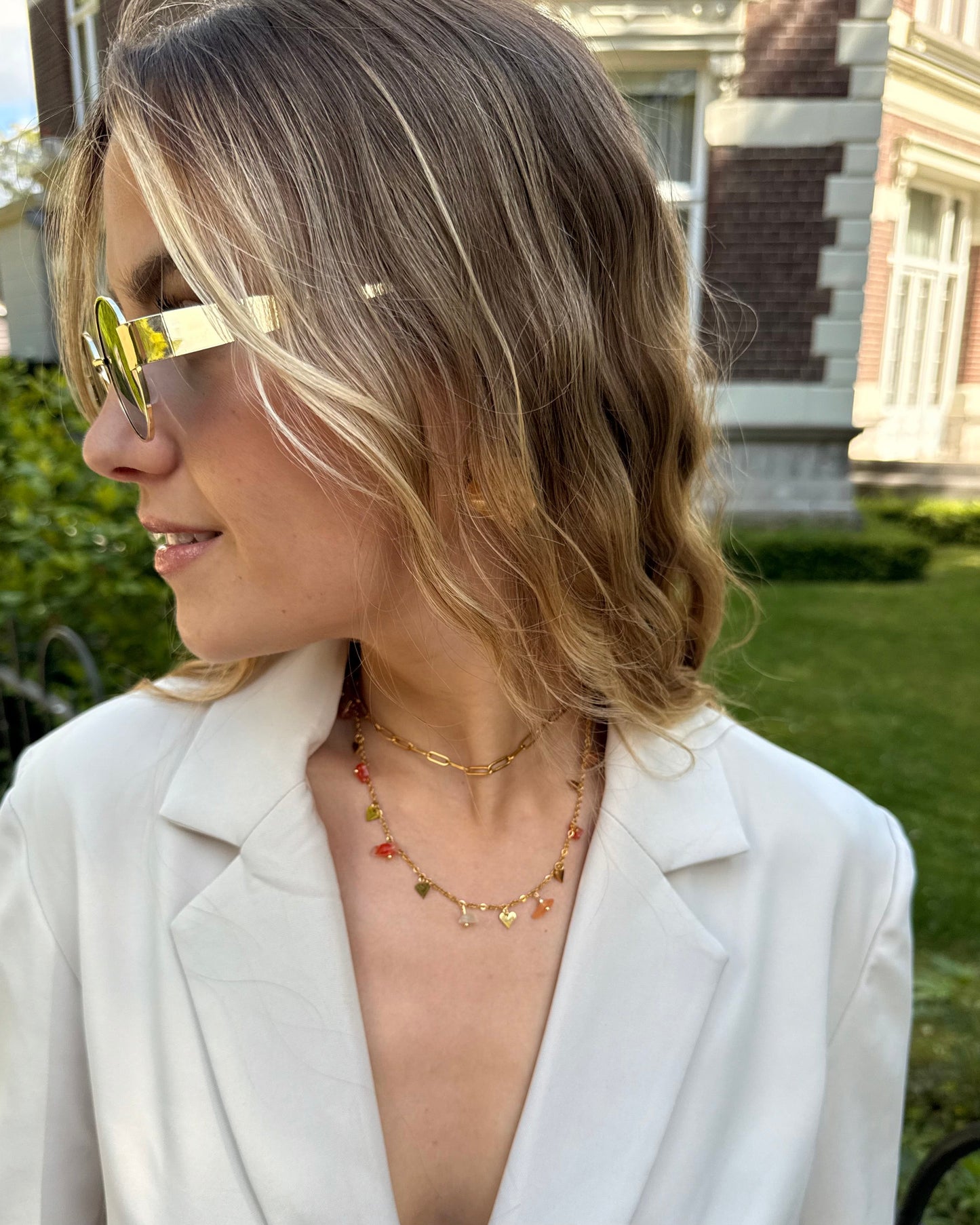 Collier double chaine en acier inoxydable. Une chaine dorée ajustable et une chaine avec des perles fantaisies oranges. 