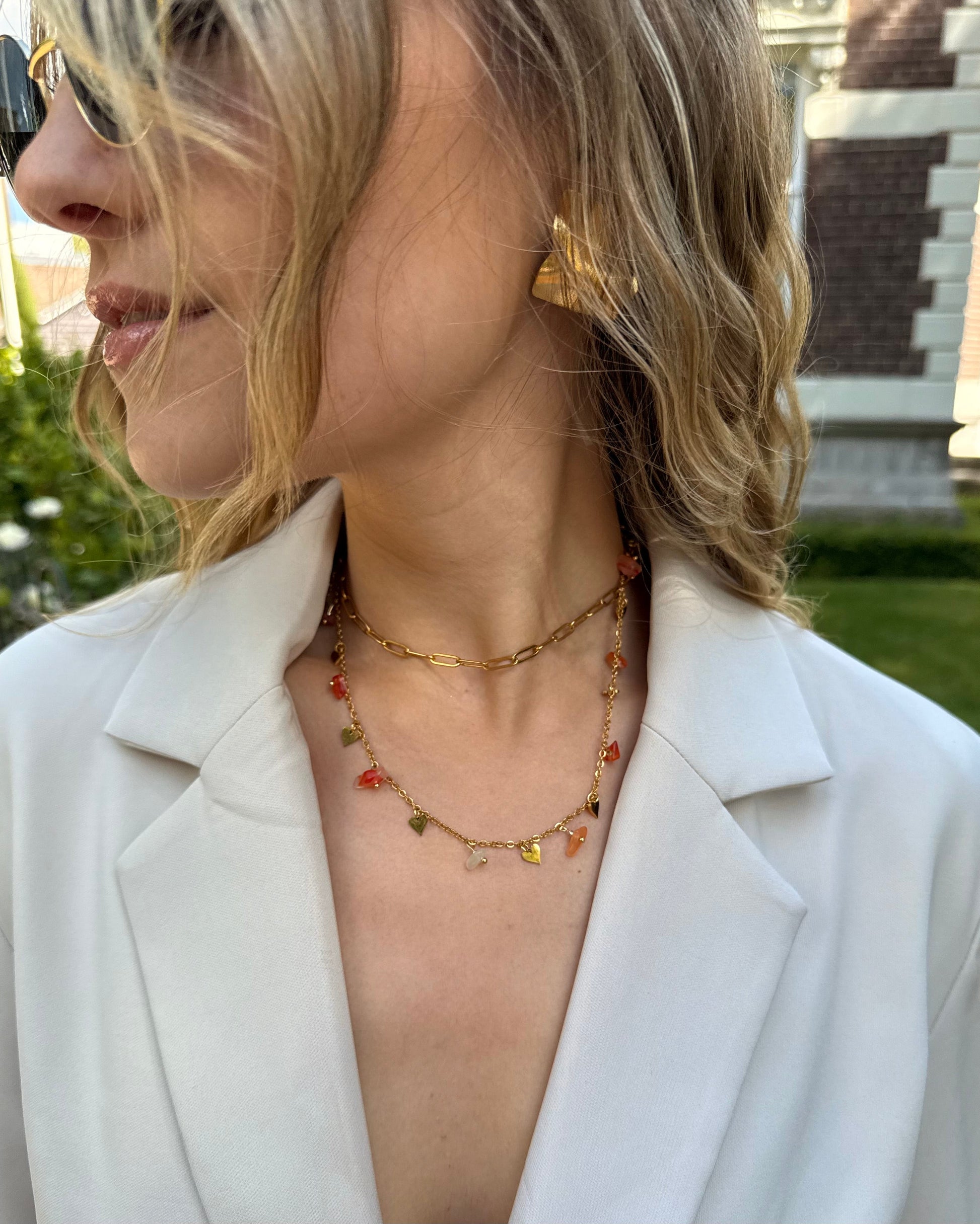 Collier double chaine en acier inoxydable. Une chaine dorée ajustable et une chaine avec des perles fantaisies oranges. 