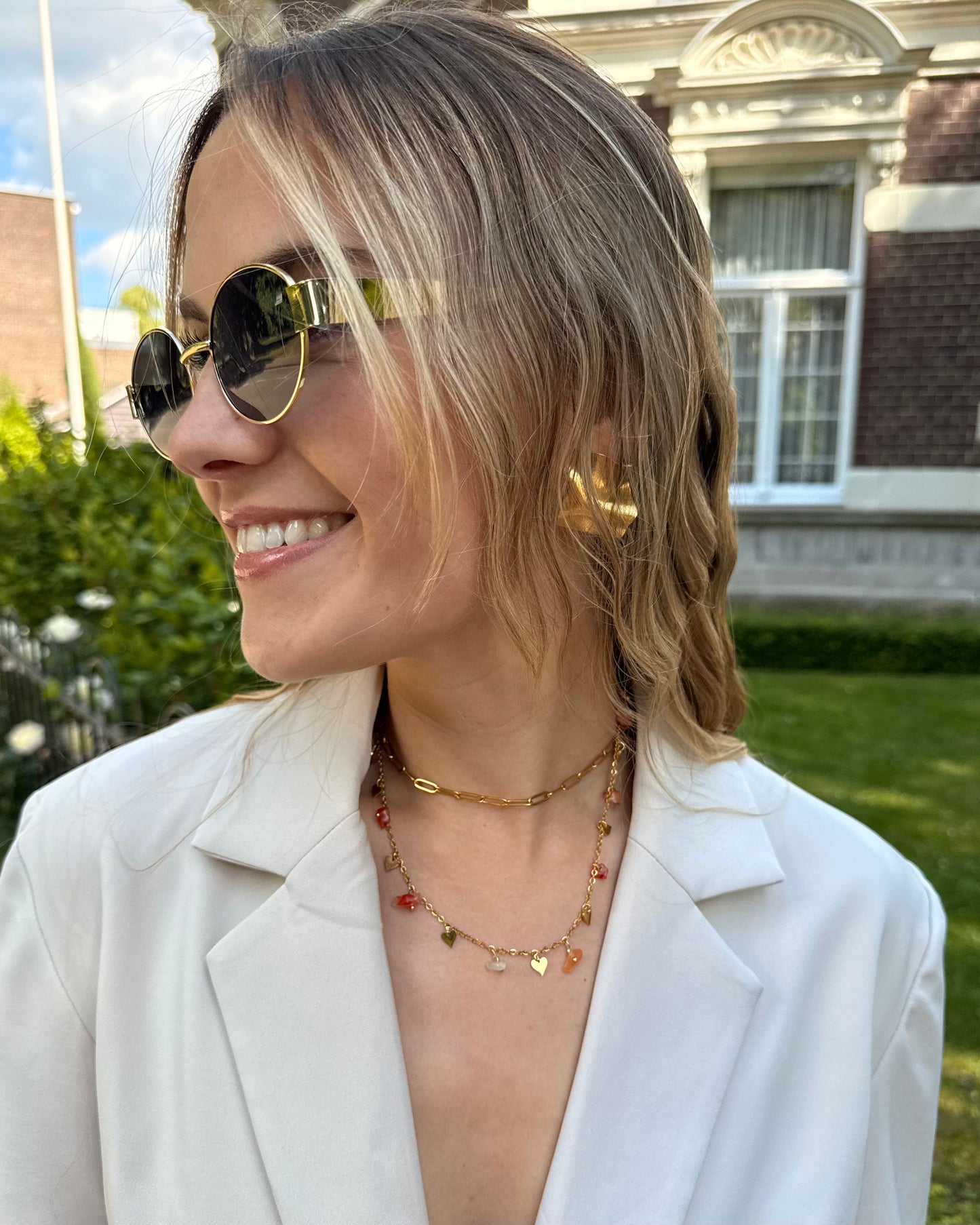 Collier double chaine en acier inoxydable. Une chaine dorée ajustable et une chaine avec des perles fantaisies oranges. 