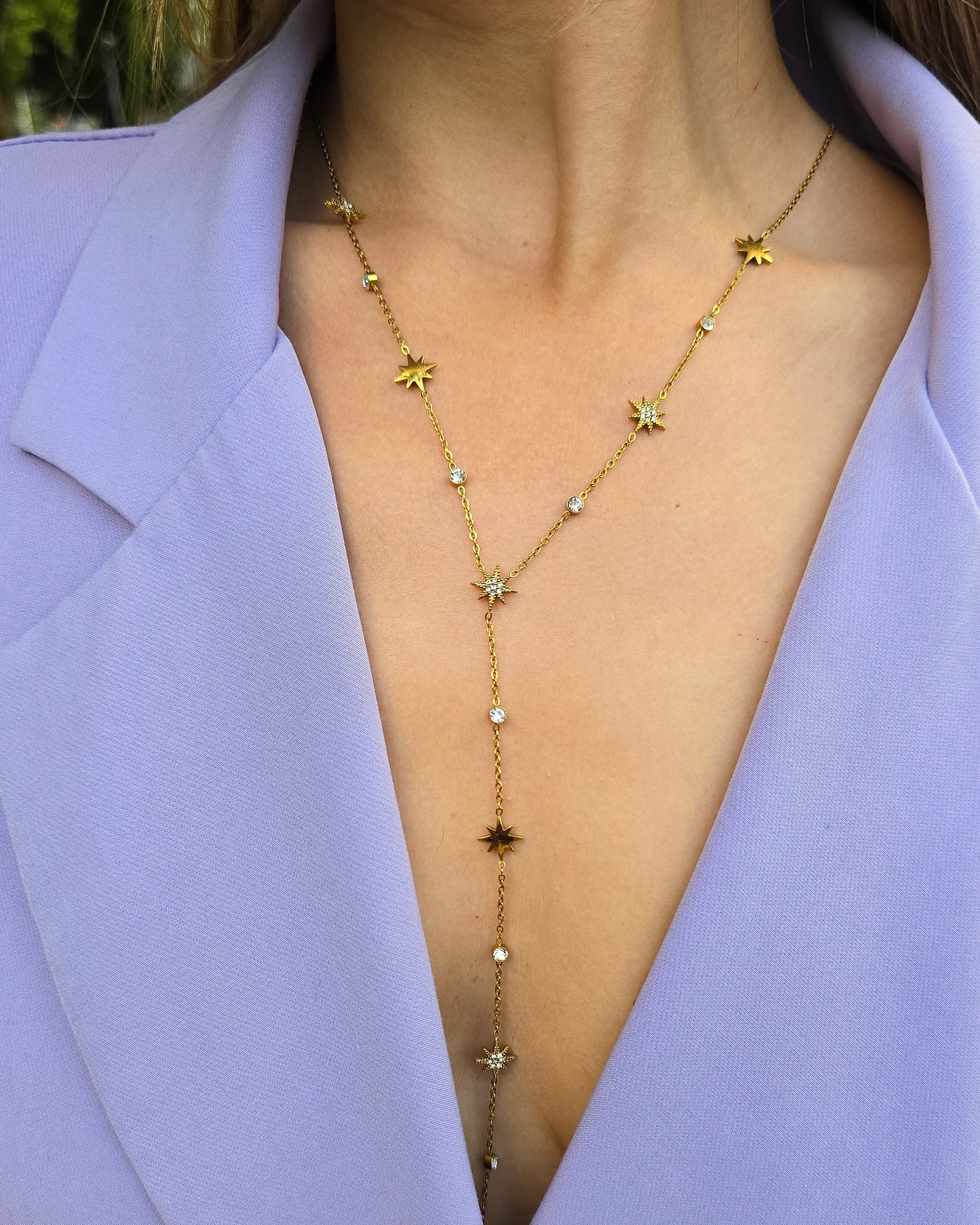 Collier doré en Y. Avec des strasses en formes d’étoiles. Longueur décolleté. 