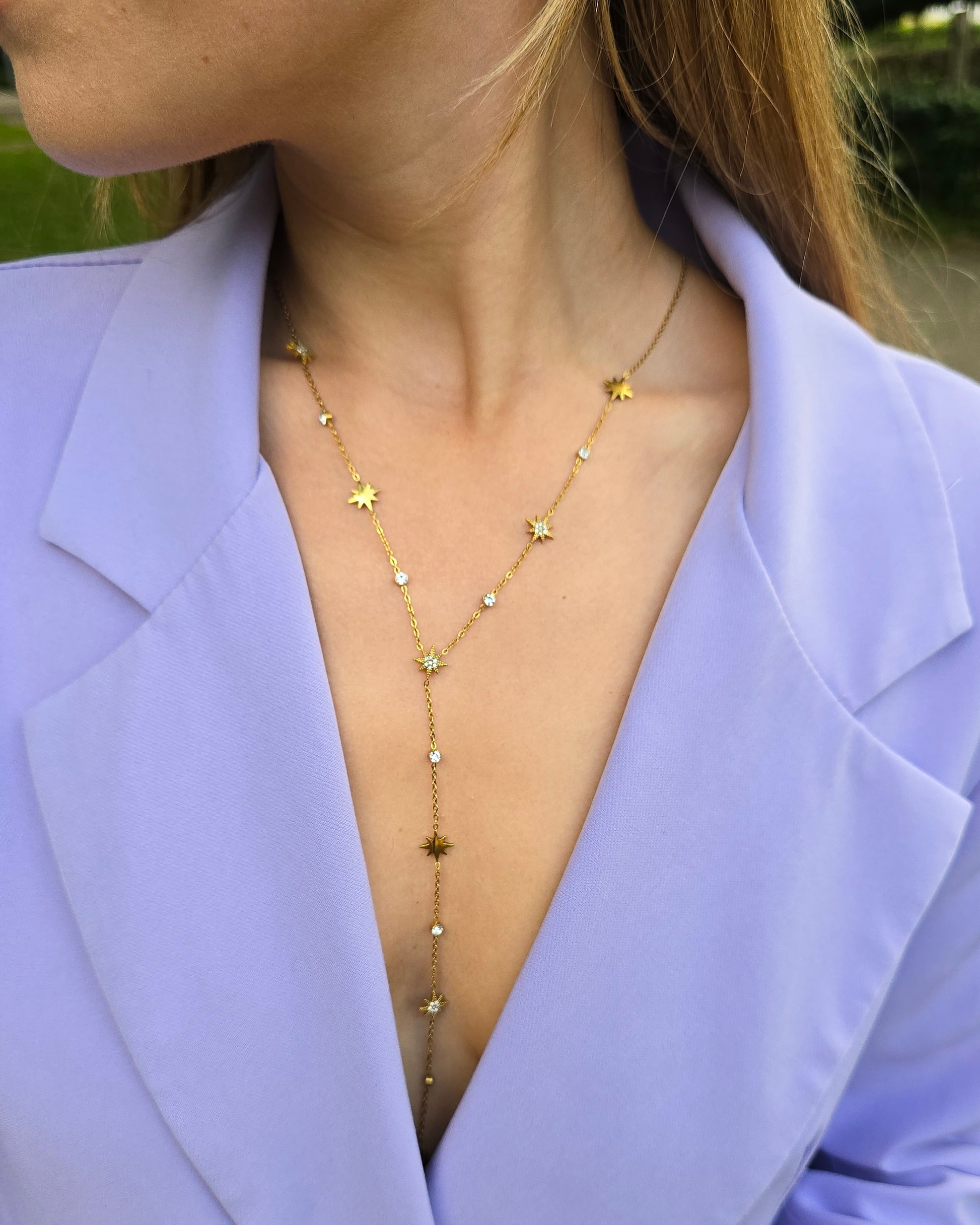 Collier doré en Y. Avec des strasses en formes d’étoiles. Longueur décolleté. 