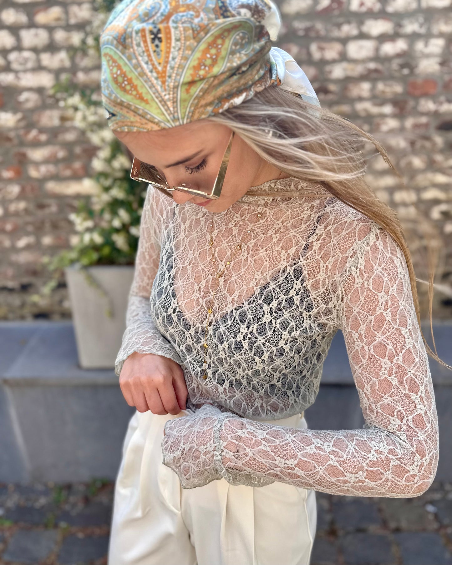 Blouse à dentelle couleur tilleul. Col montant et manches évasées. 