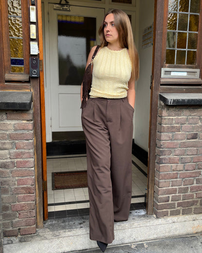 Top jaune pastel en maille texturée. Col légèrement montant avec une longueur au-dessus des hanches. 