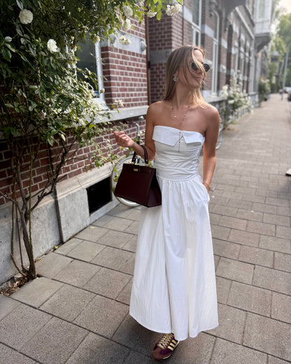 Robe blanche longue bustier. Avec effet drapé et fines bretelles. Deux poches à l’avant. 