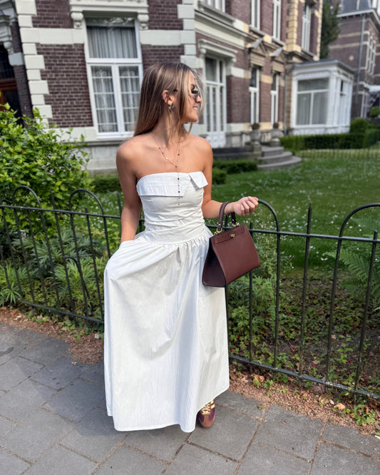 Robe blanche longue bustier. Avec effet drapé et fines bretelles. Deux poches à l’avant. 