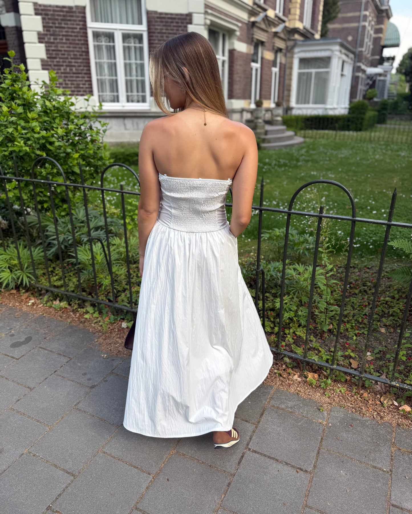 Robe blanche longue bustier. Avec effet drapé et fines bretelles. Deux poches à l’avant. 