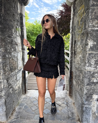 Veste noire en tweed avec deux poches à l’avant. Matière épaisse. Short noir assorti