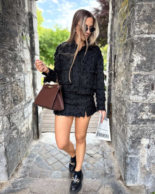 Veste noire en tweed avec deux poches à l’avant. Matière épaisse. Short noir assorti