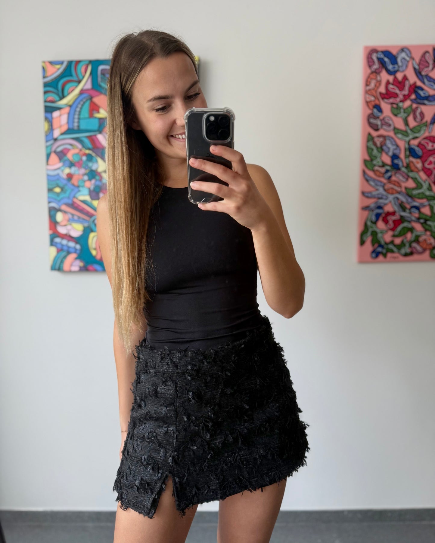 Jupe-short noire en tweed. Veste assortie. Petite fente à l’avant. Matière épaisse. 