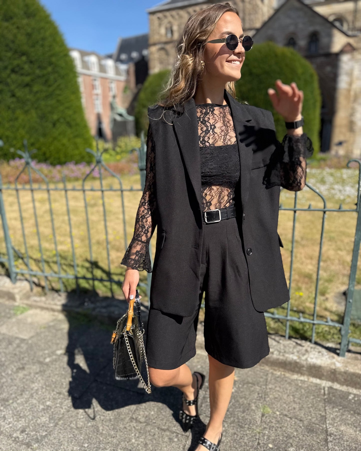 Blazer sans manches couleur noir. Deux fausses poches devant et fente à l’arrière.