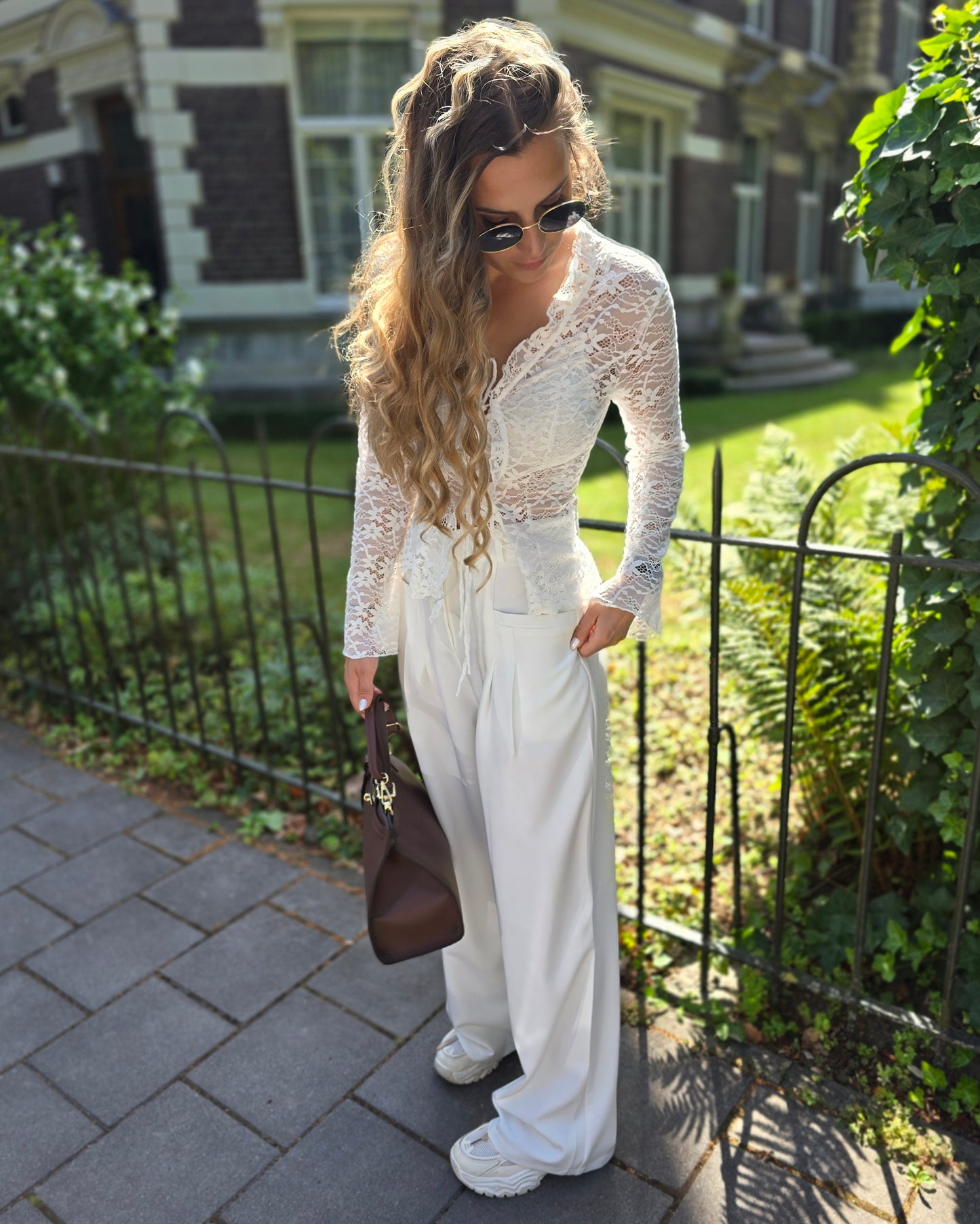 Pantalon blanc large taille haute. Deux poches à l’avant et pinçant pour ceinture. 