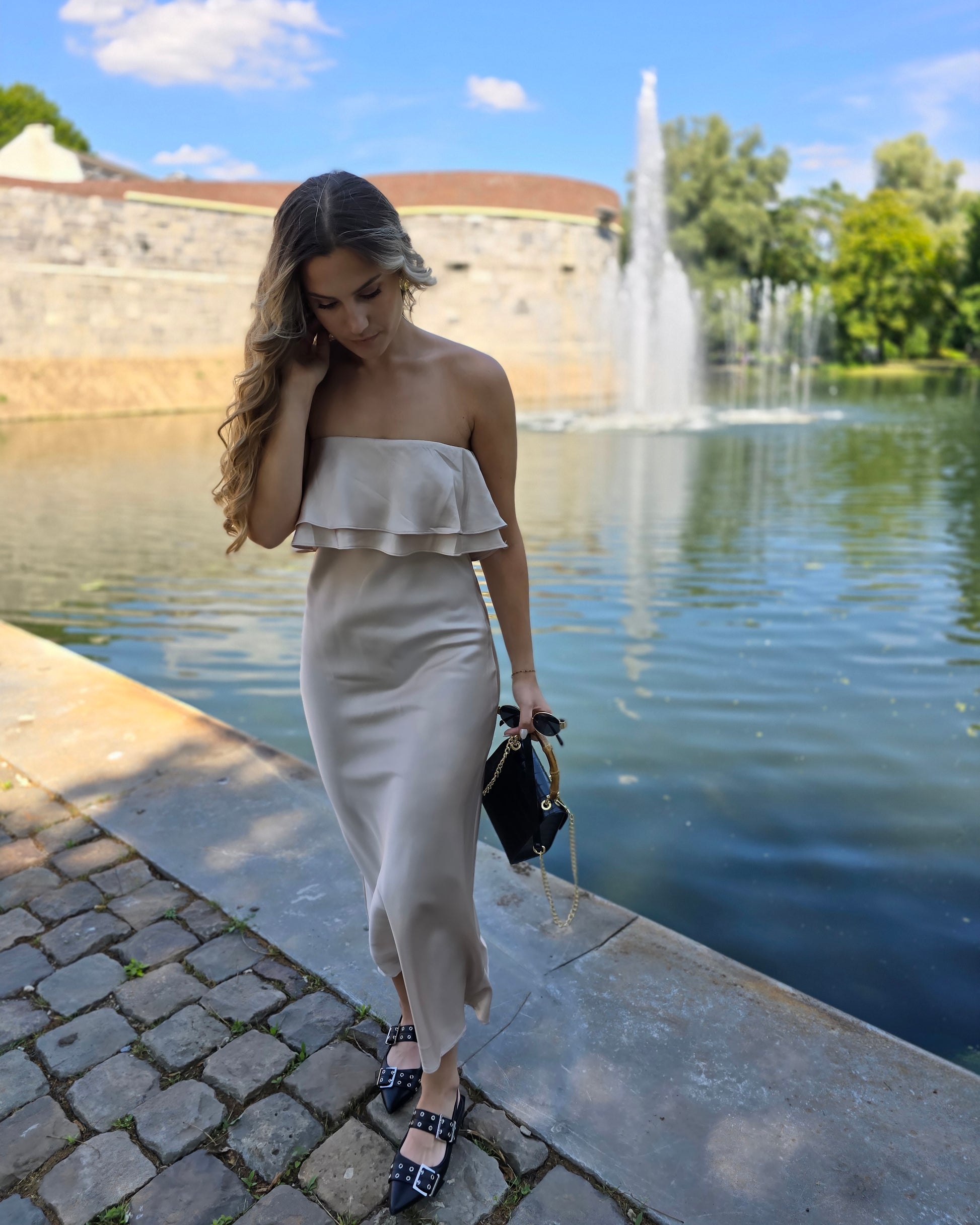 Robe dorée satinée avec volant au buste. Bandé anti-glisse. Longueur maxi.