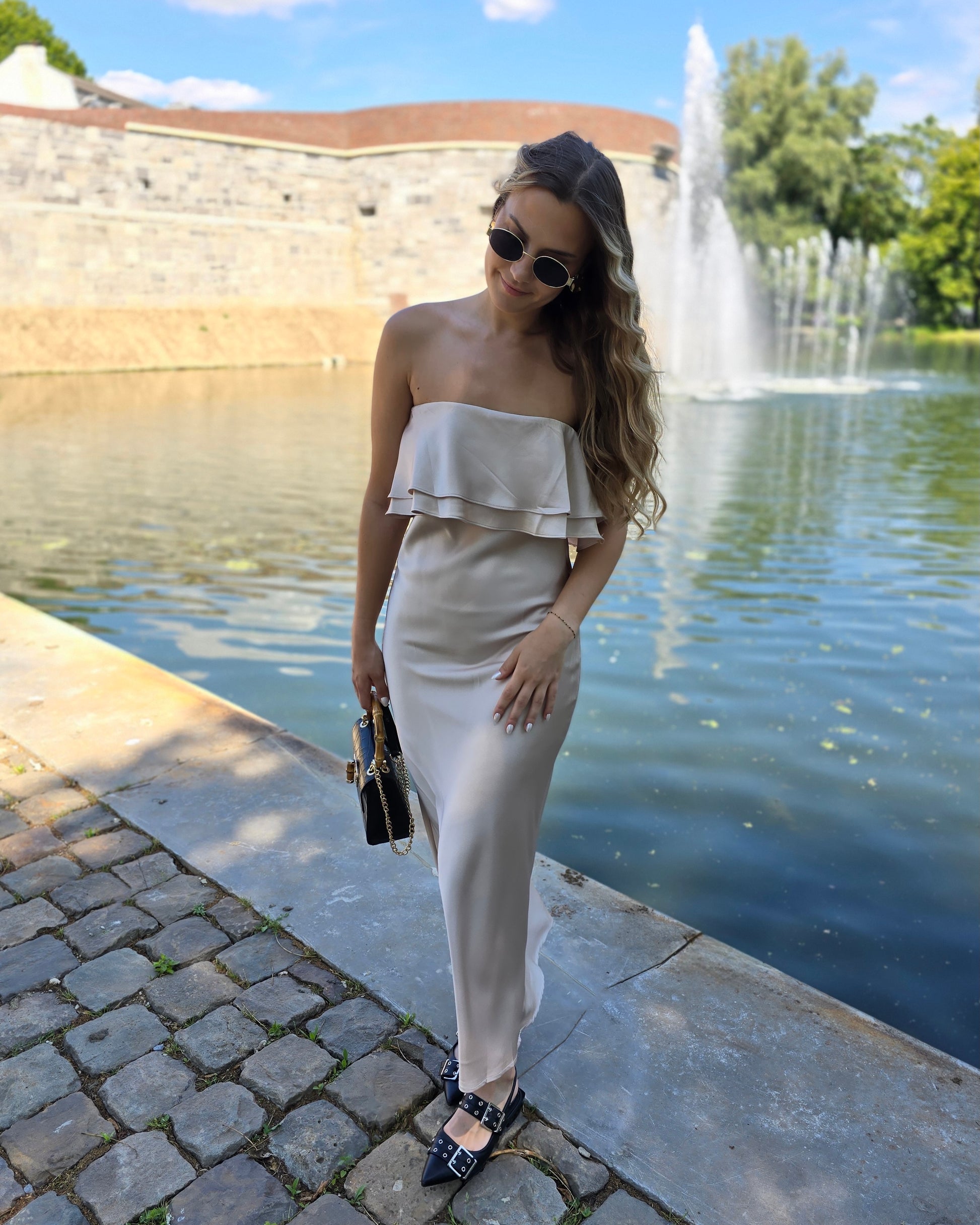 Robe dorée satinée avec volant au buste. Bandé anti-glisse. Longueur maxi.