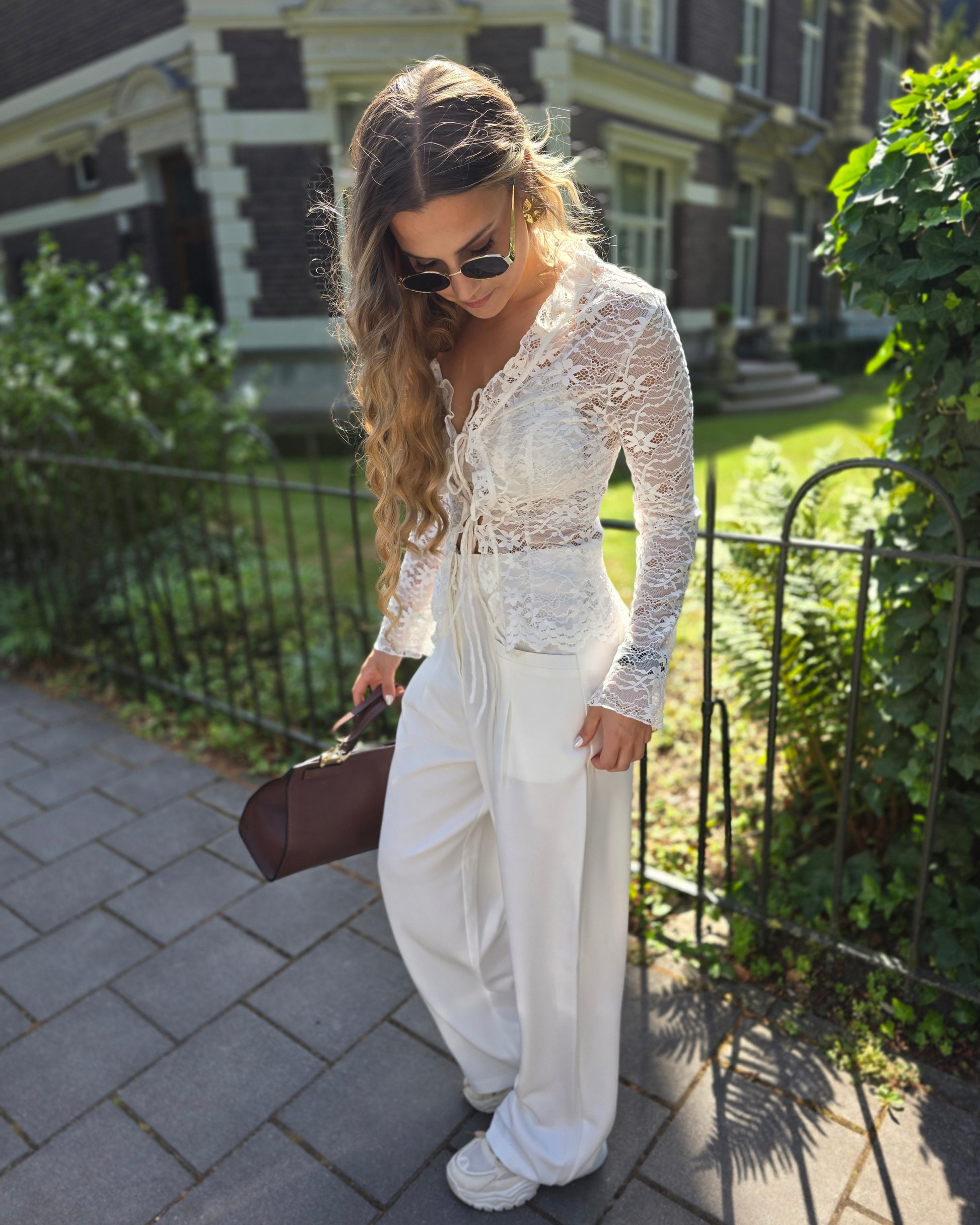 Pantalon blanc large taille haute. Deux poches à l’avant et pinçant pour ceinture. 