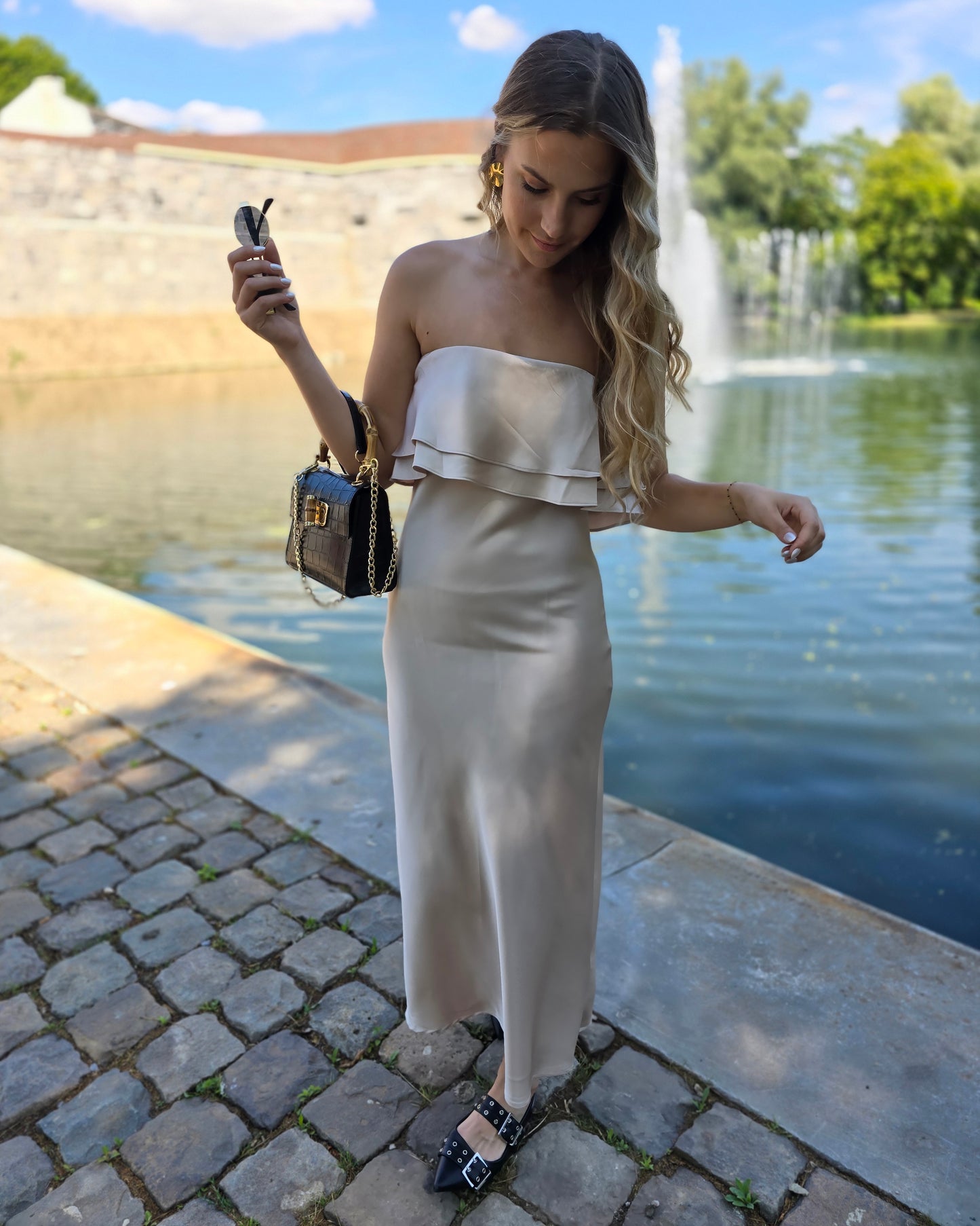 Robe dorée satinée avec volant au buste. Bandé anti-glisse. Longueur maxi.