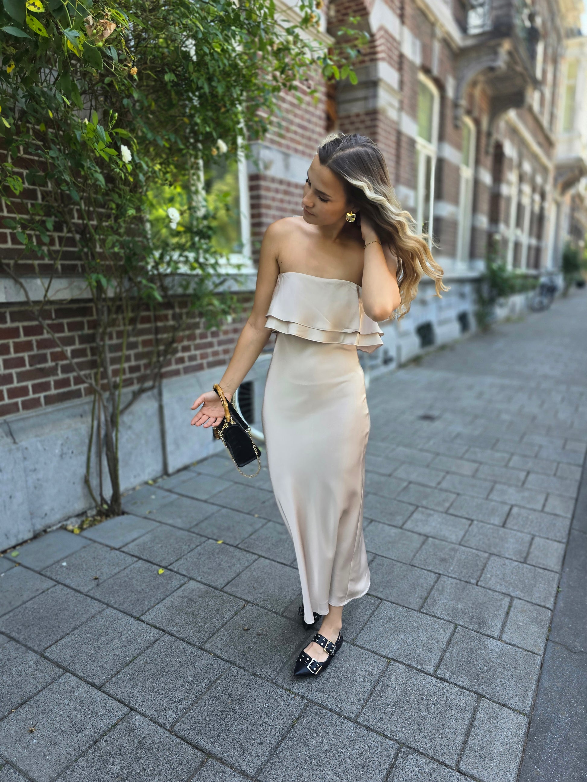 Robe dorée satinée avec volant au buste. Bandé anti-glisse. Longueur maxi.