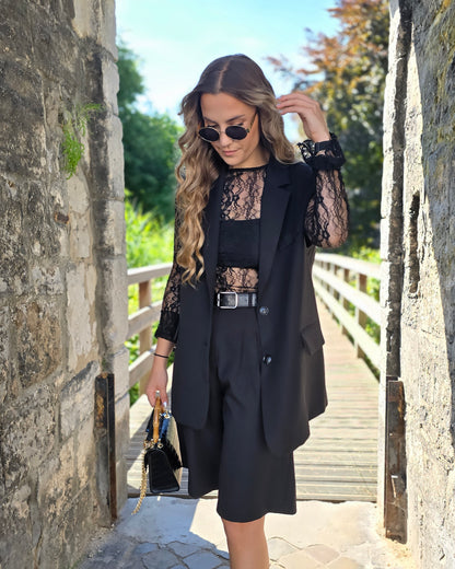 Blazer sans manches couleur noir. Deux fausses poches devant et fente à l’arrière.