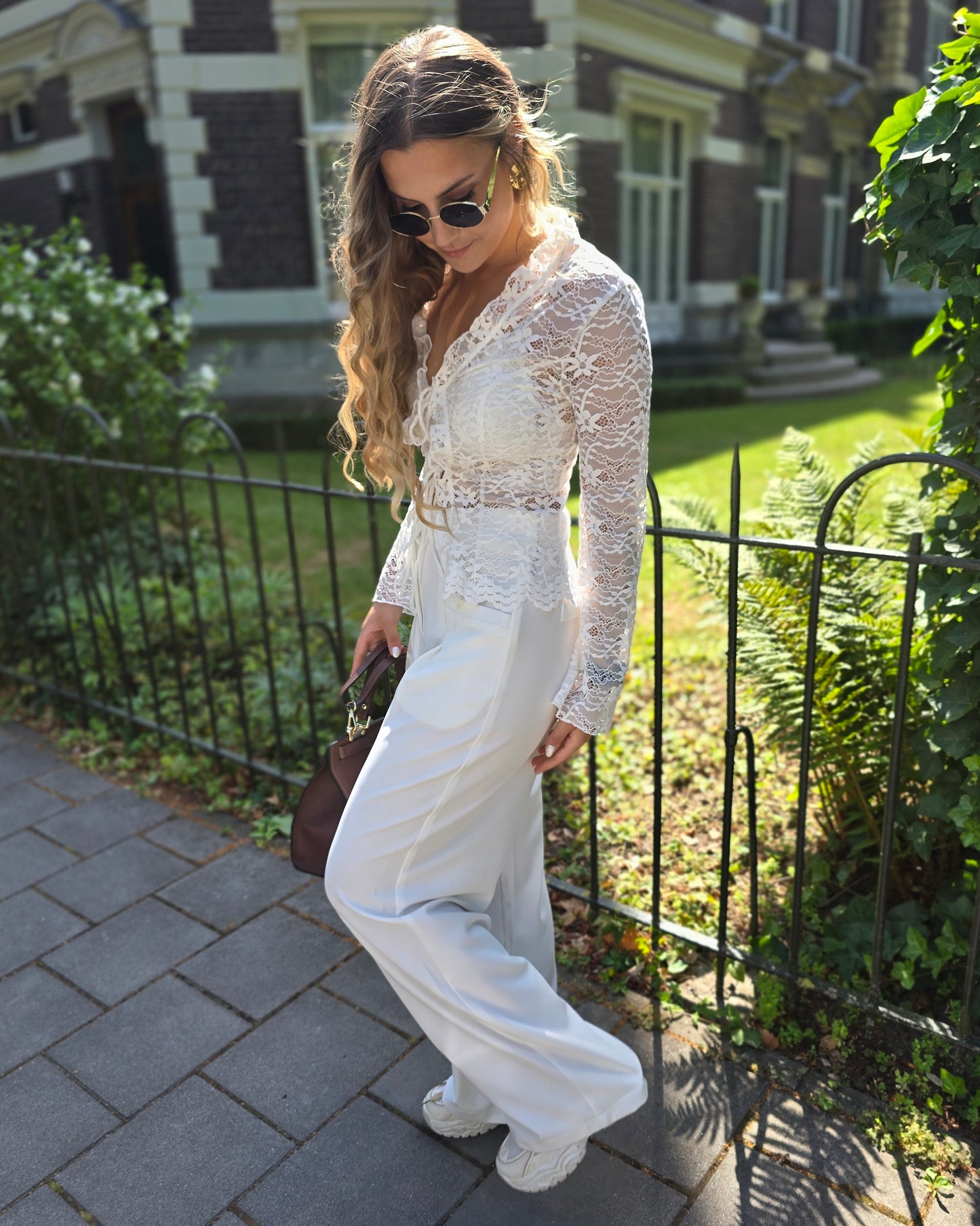 Pantalon blanc large taille haute. Deux poches à l’avant et pinçant pour ceinture. 