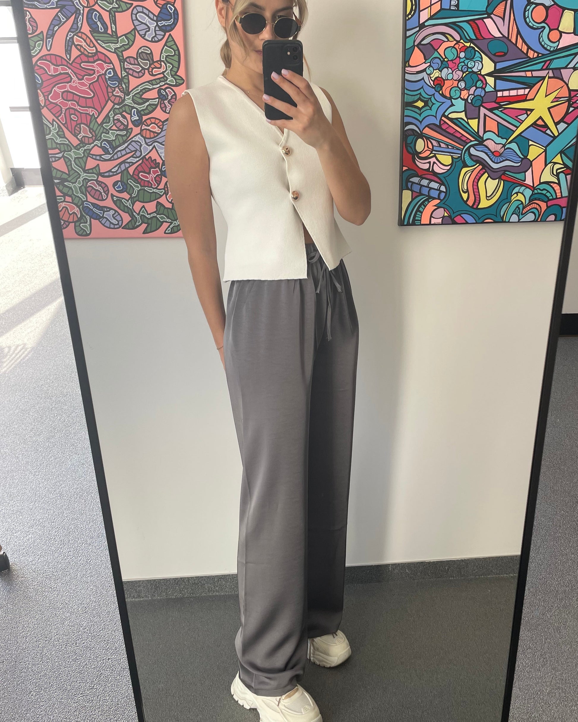 Pantalon gris foncé fluide à l’effet satin léger. Cordon à la taille, coupe droite et fluide. 