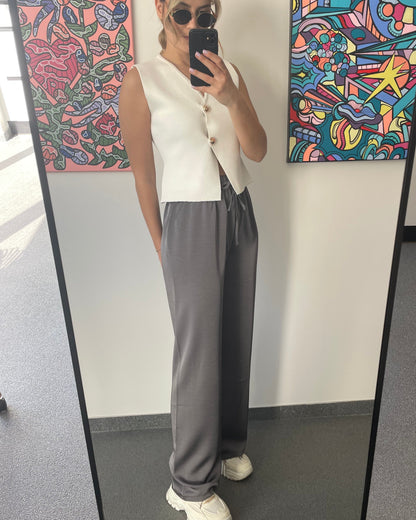 Pantalon gris foncé fluide à l’effet satin léger. Cordon à la taille, coupe droite et fluide. 