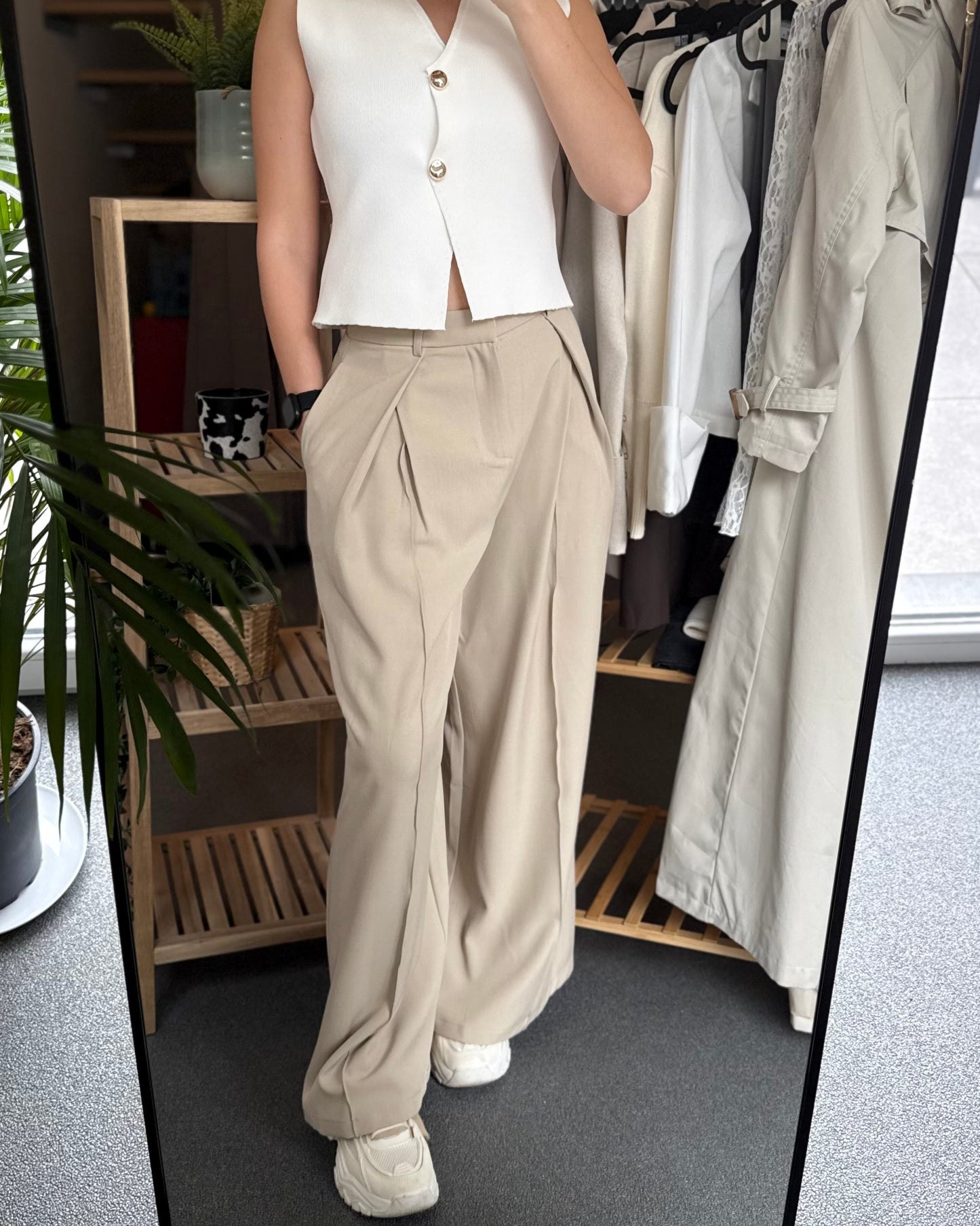 Pantalon tailleur beige taille haute. Coupe longue et fluide avec une fausse poche derrière. 