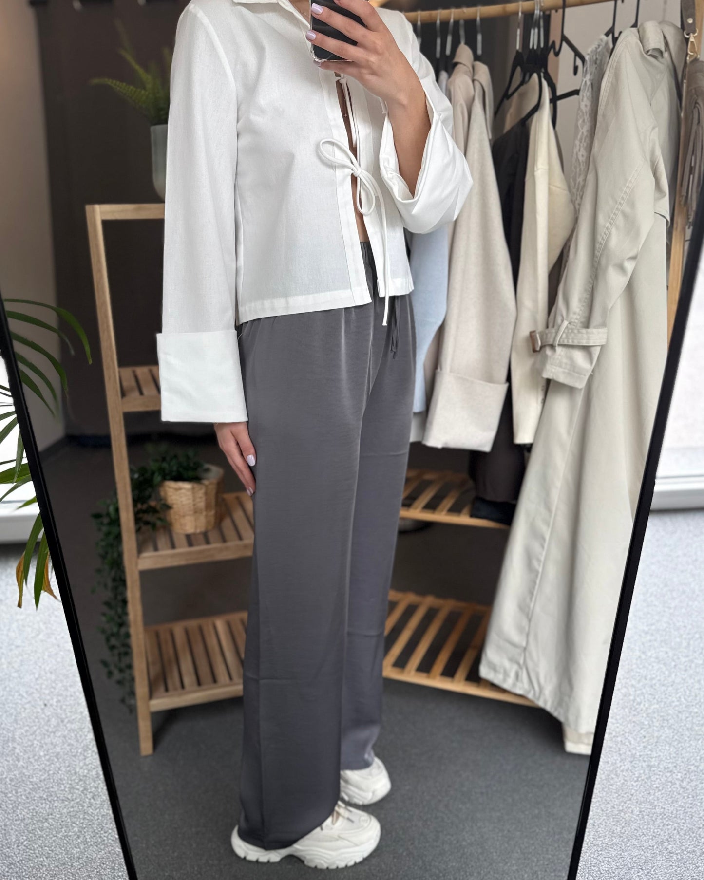 Pantalon gris foncé fluide à l’effet satin léger. Cordon à la taille, coupe droite et fluide. 