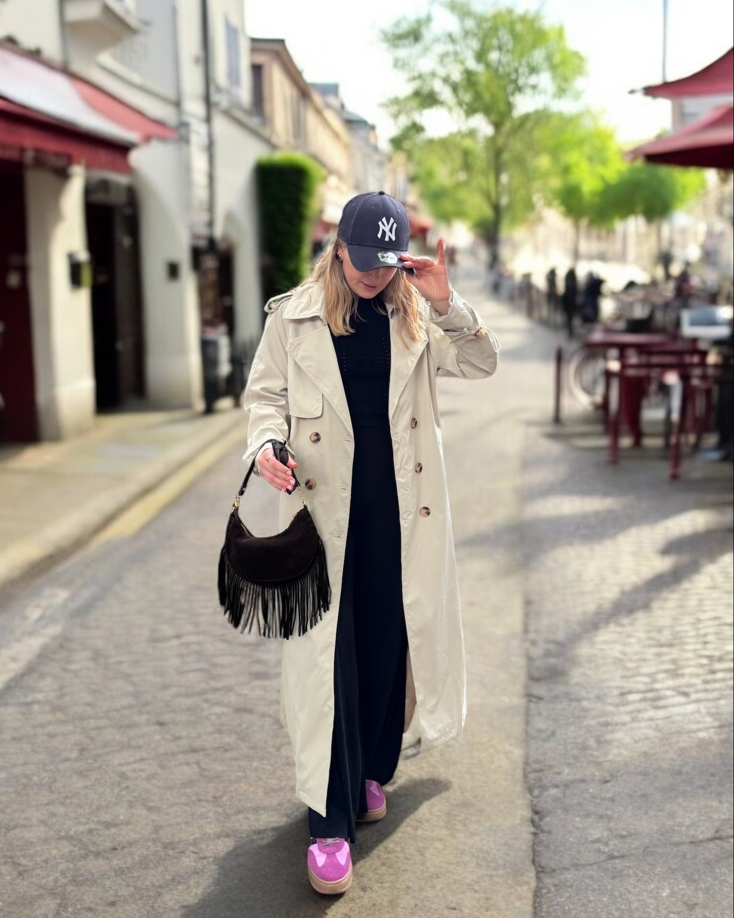 Trench beige coupe longue avec épaules structurées et une ceinture à nouer. Doublé intégralement. 