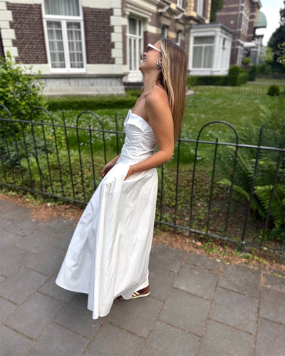 Robe blanche longue bustier. Avec effet drapé et fines bretelles. Deux poches à l’avant. 