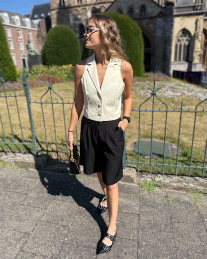 Top jaune pastel effet tailleur. Col sur l’envers et trois petit boutons sur le devant. 