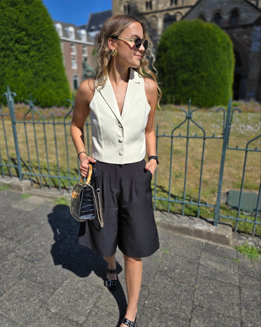 Top jaune pastel effet tailleur. Col sur l’envers et trois petit boutons sur le devant. 