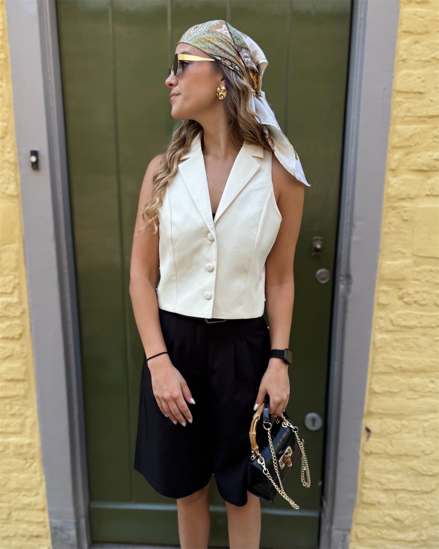 Top jaune pastel effet tailleur. Col sur l’envers et trois petit boutons sur le devant. 