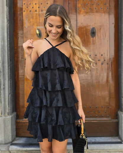 Robe noir à volant et brodée. Avec des fines bretelles sur l’avant et l’arrière. 